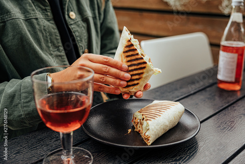 Foto Close-up of a diner holding a grilled wrap filled with meat and vegetables, with