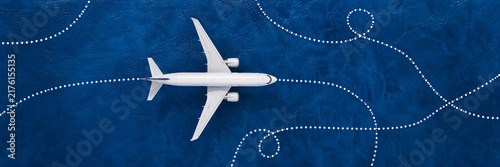 Passenger airplane with dotted white flight paths on a blue background