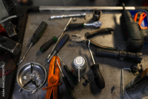 Foto Penetrating spray among scattered tools on workbench upper view