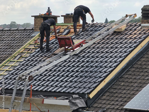 Obraz na płótnie Ouvriers qui rénovent la toiture d’une maison pour isolation et remplacement des