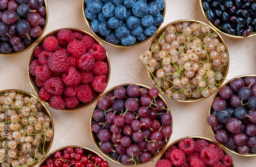 Overhead View Of Assorted Fresh Berries In Gold Rimmed Bowls