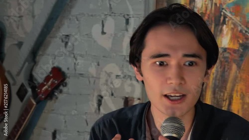 Emotional Young Asian Spiritual Leader Preaching Passionate Sermon Into Microphone During Intimate Church Gathering In Cozy Club Close Up Handheld Documentary Lifestyle Footage With Expressive Face