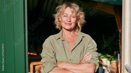 Woman in Casual Attire Standing Against Green Doorway, Posing for Portrait