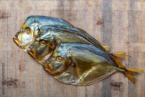 Cuadro en lienzo Three smoked sea fish close-up on a fabric background