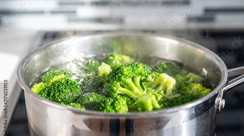 Broccoli boiling in a stainless steel pot, Fresh green broccoli cooking in water, Healthy vegetables in a stainless pan