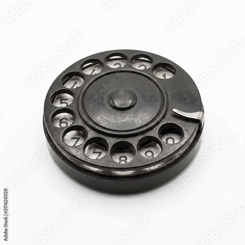 Vintage black rotary telephone dial isolated on white background featuring metallic numbers and classic mechanical design for antique communication collectors