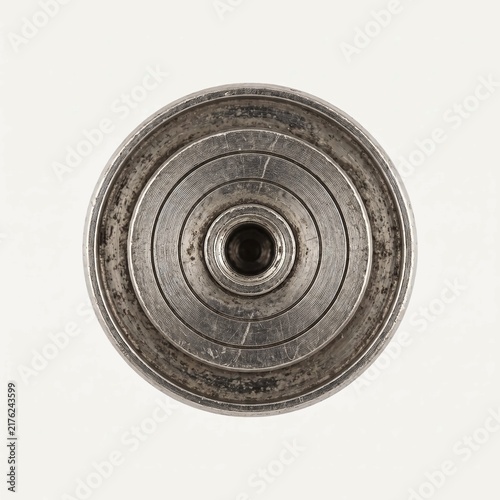 Metallic industrial piston component featuring circular machined ridges and weathered steel textures captured from an elevated top down macro camera angle