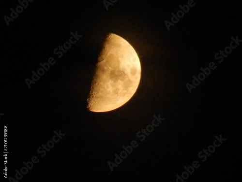 Quadro su tela Lune dorée partiellement éclairée dans un ciel nocturne noir