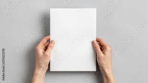Hands holding a blank white paper sheet mockup