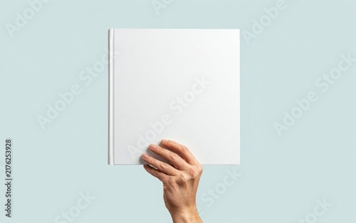 Hand holding a blank square book cover mockup