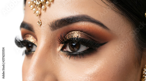 Stunning close-up of a bride with perfectly groomed eyebrows and dramatic eye makeup in a professional studio setting for her marriage.
