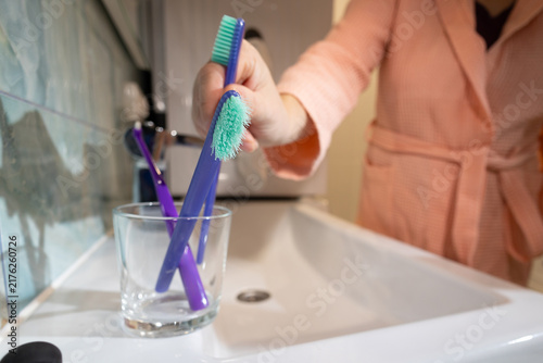 Fotografie Person holds two toothbrushes, old and new, to emphasize timely replacement for