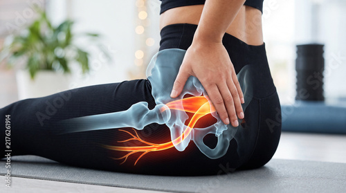 Seated woman on yoga mat with glowing sciatic nerve and hip joint pain overlay, medical concept