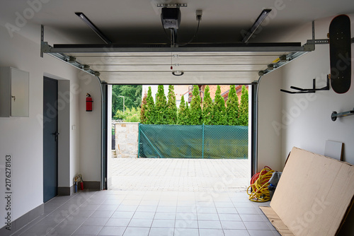 Obraz na plátně Open sectional garage door with automatic opener inside residential garage