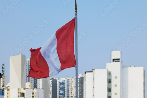 Fotografie Peruvian flag waving high over lima cityscape