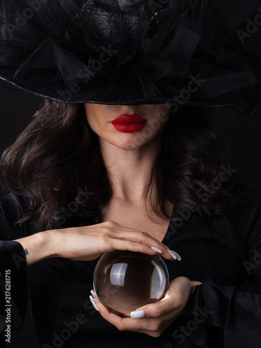 Beautiful young woman wearing witch costume holding a broomstick