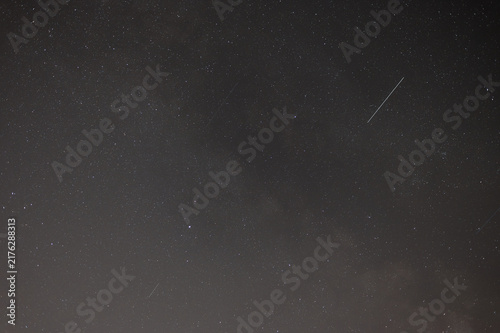Starry Night Sky Background with Faint Meteor Trails and Deep Space Stars