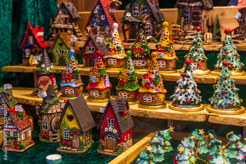 Naklejka premium Traditional ceramic Christmas tree candle holders and fairy houses for sale at the Christmas market in Regensburg, Germany
