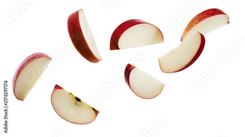Fotografie Fresh red apple slices falling in midair