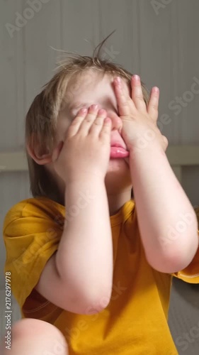 Boy joking, sticking tongue out with silly expression. Child making face. Funny foolishness portrait of little baby boy on white background. Adorable caucasian kid making crazy and comical gesture.