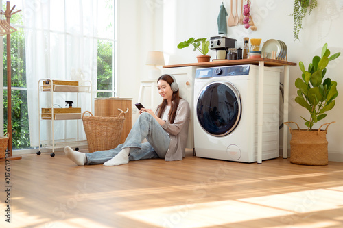 woman Listening to Music While Doing Laundry at Home in the Morning