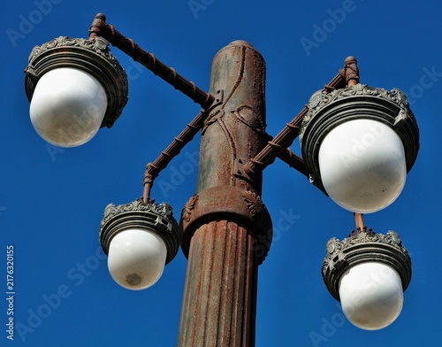 Ornate antique street lamp with multiple lights against blue sky. Sigtes, Tarragona - Spain