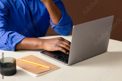 Person Working on Laptop With Notebook and Pencil