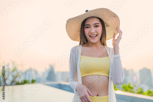 Foto Portrait of cheerful smiling young woman wearing sun hat enjoying golden hour sunset at luxury rooftop, radiating joyful optimism, vitality, happiness, freedom, and vacation vibes