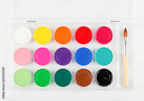 Set of colorful watercolor paint pans with a small brush