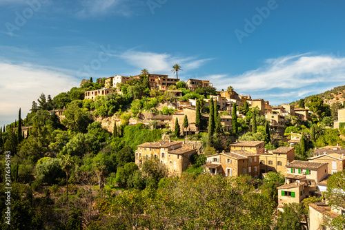 Scenic hillside village with traditional stone houses under blue sky