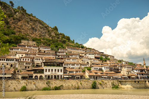Historic houses on hillside in Berat, Albania under a blue sky