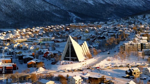 Side lit telephoto drone view of iconic Arctic Cathedral in winter in Tromso