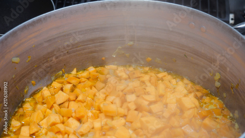 Konstfotografi Sweet potato cubes are simmering in a large aluminum pot on a commercial gas sto