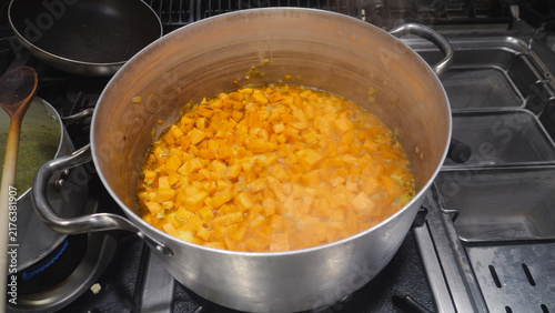 Quadro su tela Sweet potato cubes are simmering in a large aluminum pot on a commercial gas sto