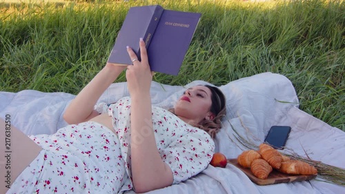 A Relaxing Woman Enjoys Reading Outdoors While Indulging in Snacks