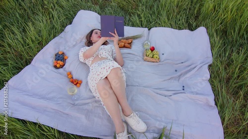 A Relaxing Picnic Scene Featuring a Woman Enjoying Reading in Nature
