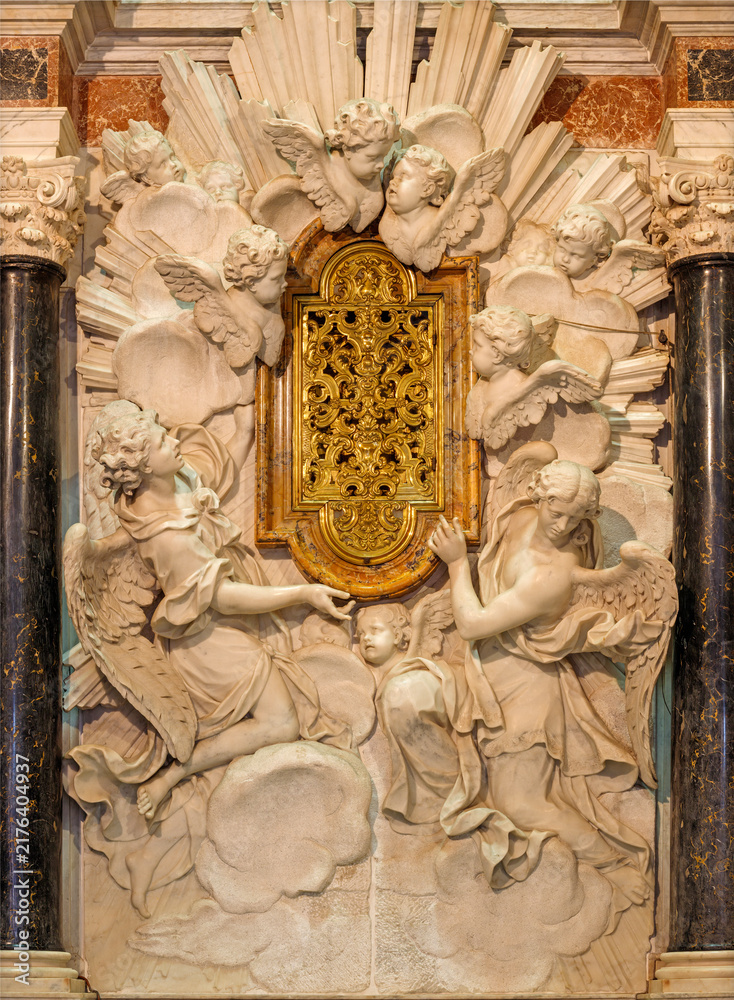 Fototapeta premium LUCCA, ITALY - JUNE 23, 2026: The marble tabernacle (Reliquia del Sangue Preziosissino) in the Cenami chapell in the church Basilica di San Frediano by Giovanni Baratta from 18. cent. 