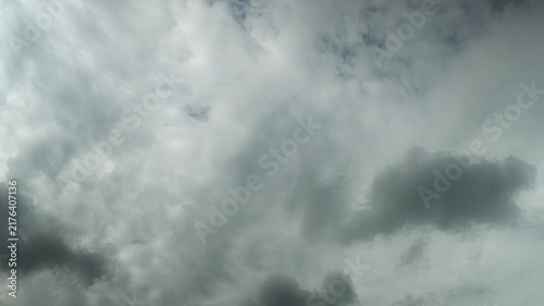 Timelapse of grey and white summer clouds drifting across a blue sky
