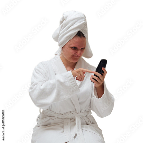 Bild auf Leinwand Woman in bathrobe and towel on head holding and pointing at smartphone with annoyed expression