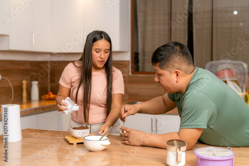 Fotografía Young couple preparing food together in kitchen