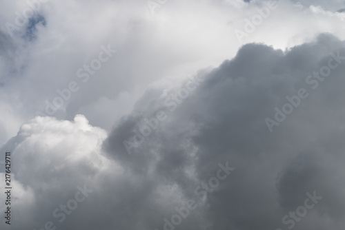 Storm cloud gathering. Dark storm cloud building rapidly. Eminent thunderhead with fierce swirling formations. Overhanging storm cloud with turbulent structures and heavy moisture