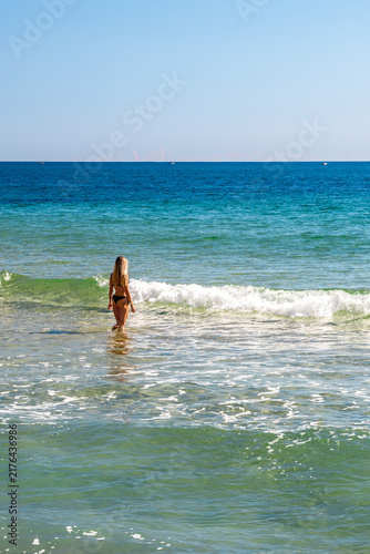 Woman standing in turquoise Black Sea water at Byala beach in Bulgaria