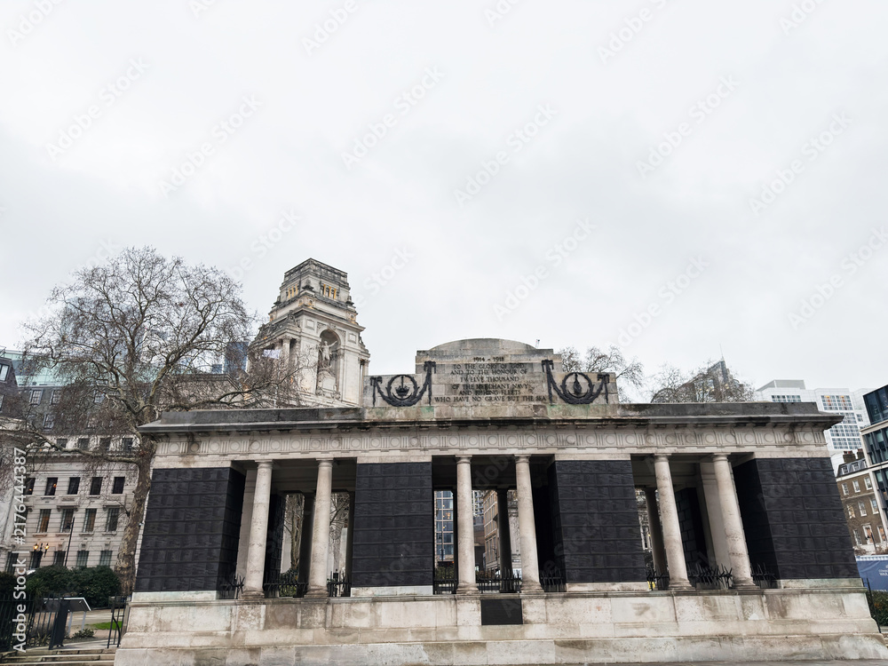 Obraz premium Urban war Tower Hill Memorial in London, UK with classical columns and pedestrians walking past on cloudy day. The Mercantile Marine Memorial.