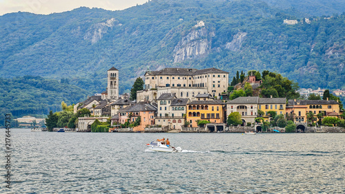 San Giulio Island on Lake Orta, Piedmont, Italy. Aerial panoramic view featuring the historic basilica and picturesque lakeside scenery surrounded by Alpine landscapes