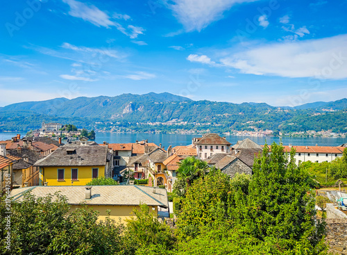Panoramic view of Orta San Giulio on the shores of Lake Orta, Piedmont, Italy. Aerial drone view showcasing the historic lakeside town and picturesque Alpine landscape