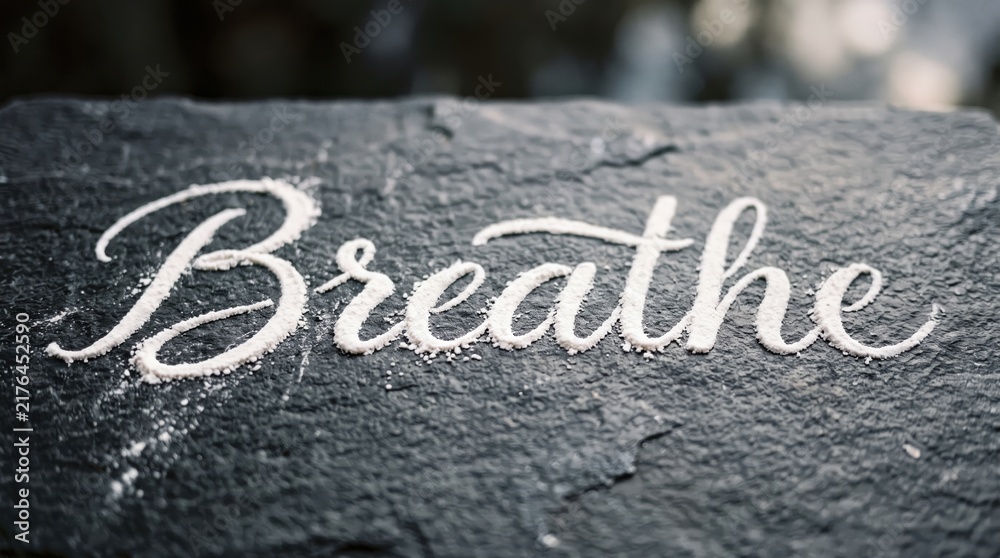Fototapeta premium Breathe flour inscription banner with dark textured surface and calming atmosphere
