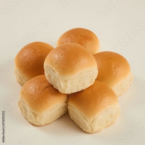 Soft dinner rolls stacked on white background