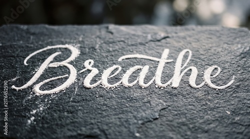Breathe flour inscription banner with dark textured surface and calming atmosphere