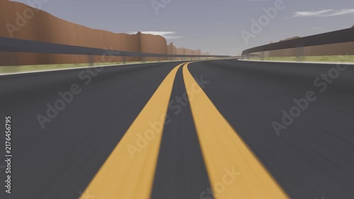 Starting low camera moving along desert canyon road simulating travel and showing yellow lines