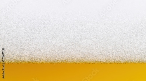 Extreme close up of beer foam and golden liquid texture for beverage background.